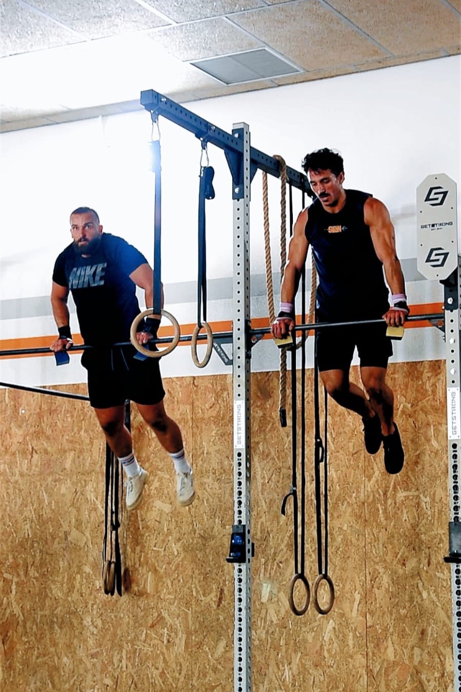 Dos atletas haciendo fondos en barra en la estructura de anillas de Siron Fitness Club